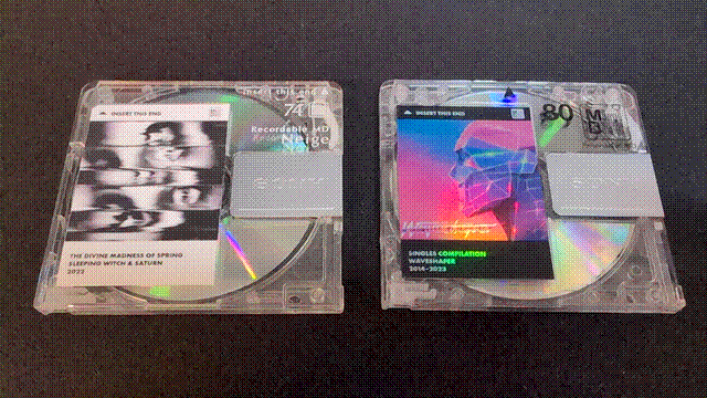 Two MiniDiscs. The one on the left has a black-and-white label for the Sleeping Witch & Saturn album 